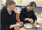 Gretchen Finseth and Vara Kutsev show off their baking skills during Career and Technical Education Month at Win-E-Mac School.