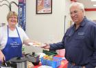 Nancy Schmit helps Russ Crawford, Manager of the Gully Coop.