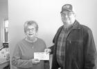 Clearwater County Food Shelf Site Manager Sharon Braaten accepts a donation from Roger Bachmann of the Bemidji Coop Association.