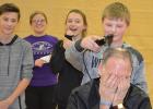 As an incentive for the students raising money for the Clearwater Christmas Project, Bagley High School Principal David Gooch allowed the winning classroom to shave his head during the December 21 assembly.  Mrs. O’Beirne’s eighth grade class earned the honor and gathered around to watch their classmate Kyle Baumann trim the first locks of hair from their principal.  