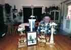 Bennie Erickson with some of his trophies and the picture that was in the Leader-Record in 1971.
